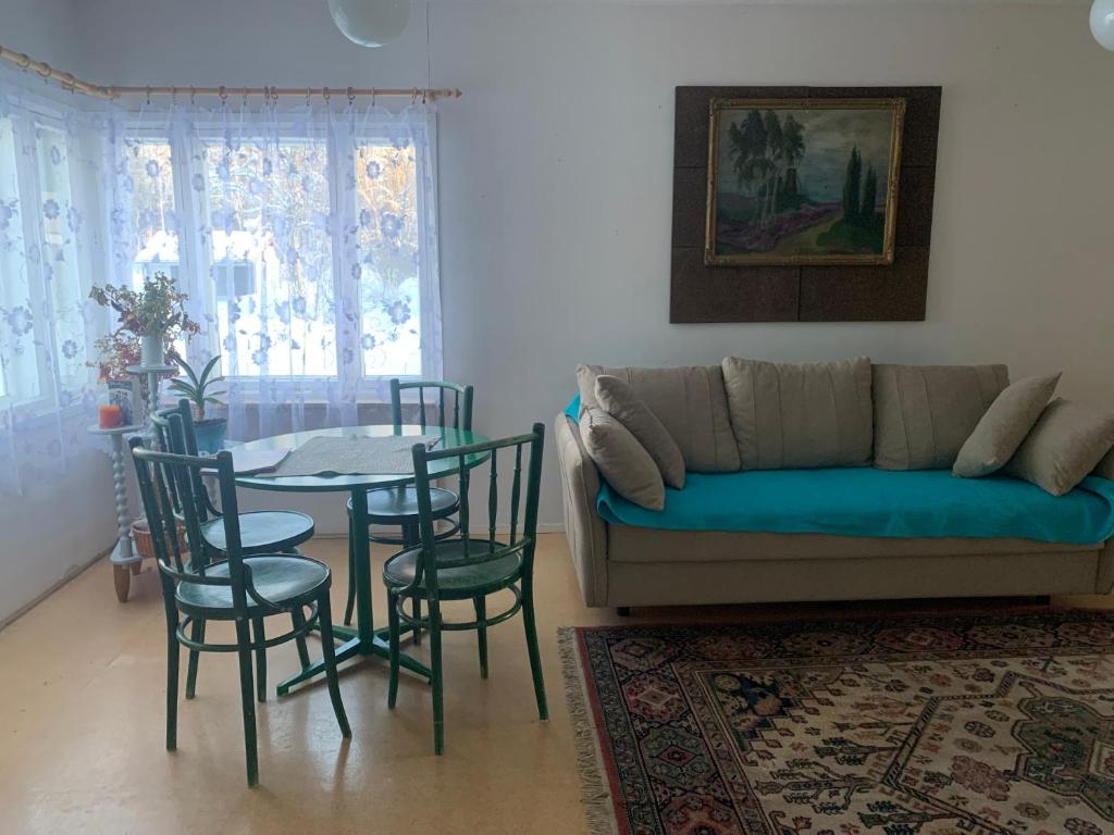 a living room with a couch and a table and chairs at Koskelo in Kiuruvesi
