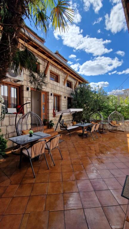 a patio with tables and chairs in front of a building at Pansion Oscar Summer Garden in Mostar