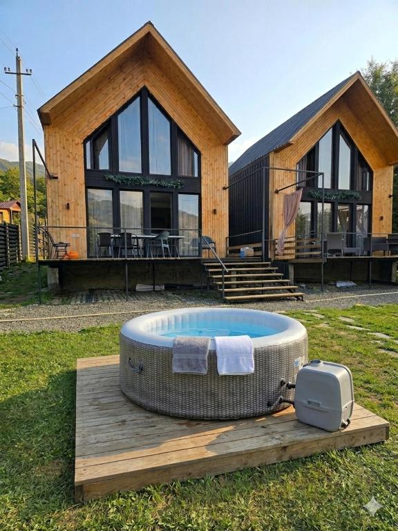 a house with a hot tub in front of it at Chalet Weekend in Borjomi