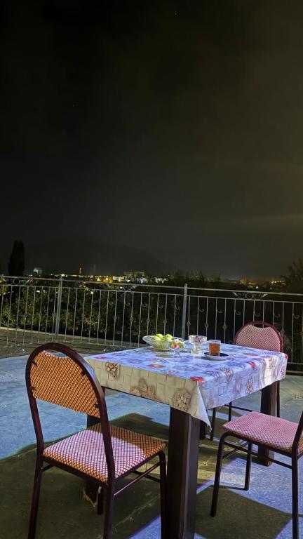 a table with two chairs and a table with food on it at Sheki Ev Guest House in Sheki