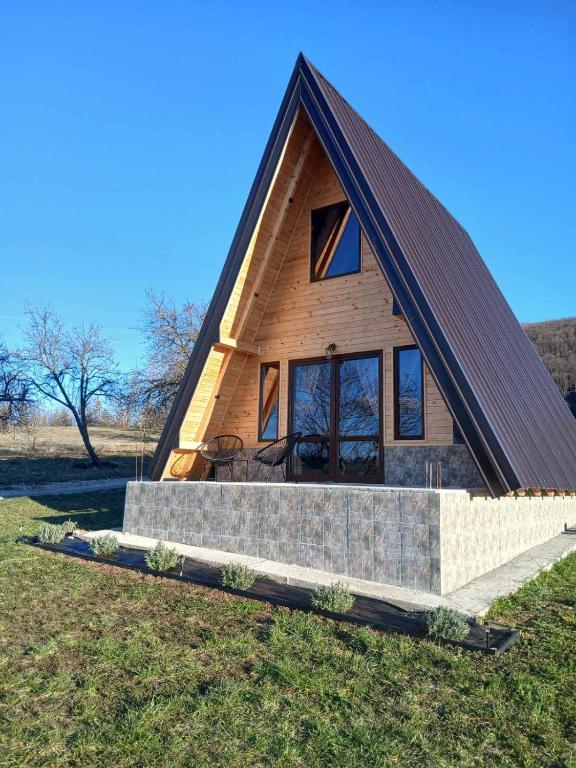 a small house with a pitched roof on a field at Vikendica Bogdanović in Nova Varoš