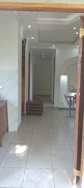a room with a hallway with a staircase and a table at Perfect Backpacker Spot in Shimoni