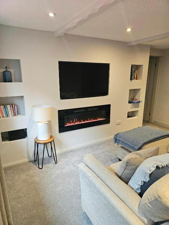 a living room with a tv and a fireplace at Last Yan - Stylish Ambleside Stay in Ambleside