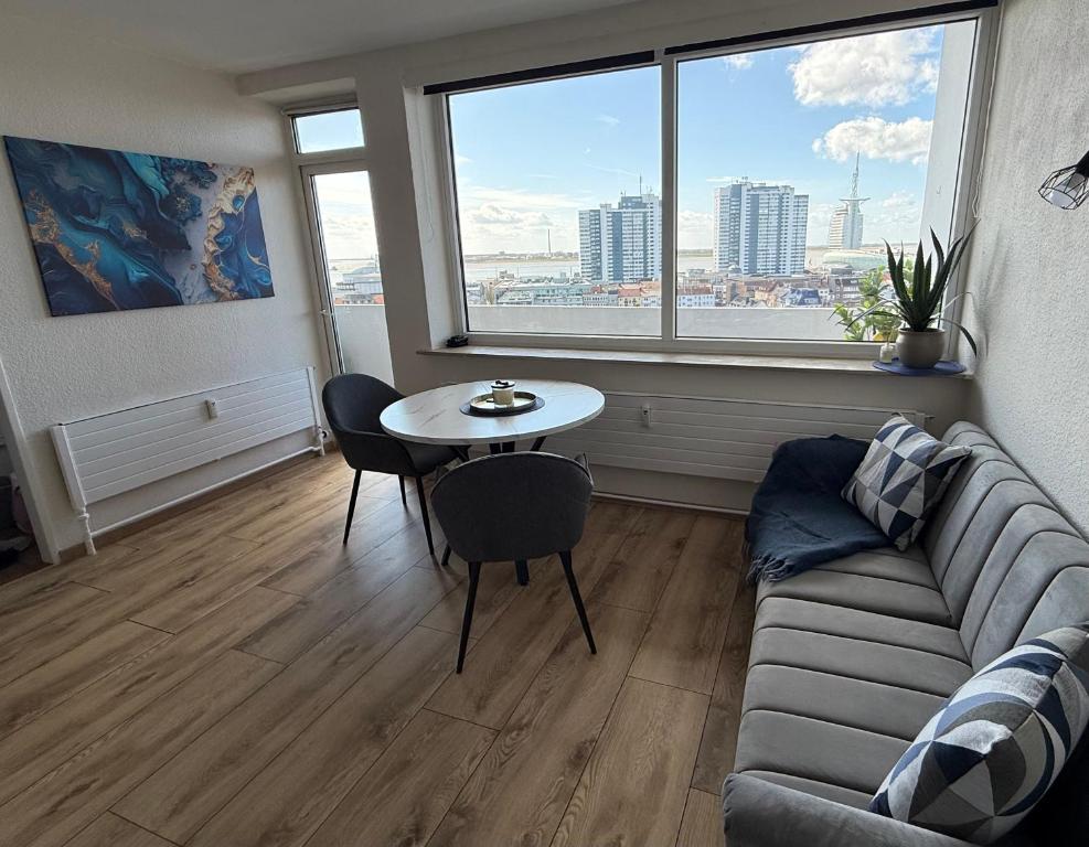 a living room with a couch and a table at Cloud 12 - Penthouse in der Innenstadt mit Blick über die gesamte Skyline von Bremerhaven in Bremerhaven