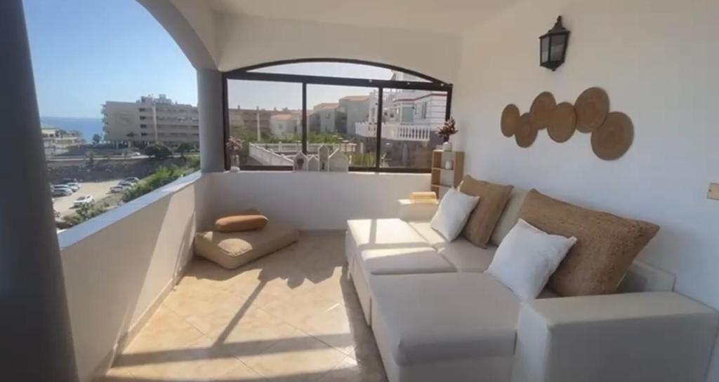 a living room with a white couch and a large window at Flamingo 1 in Arguineguín