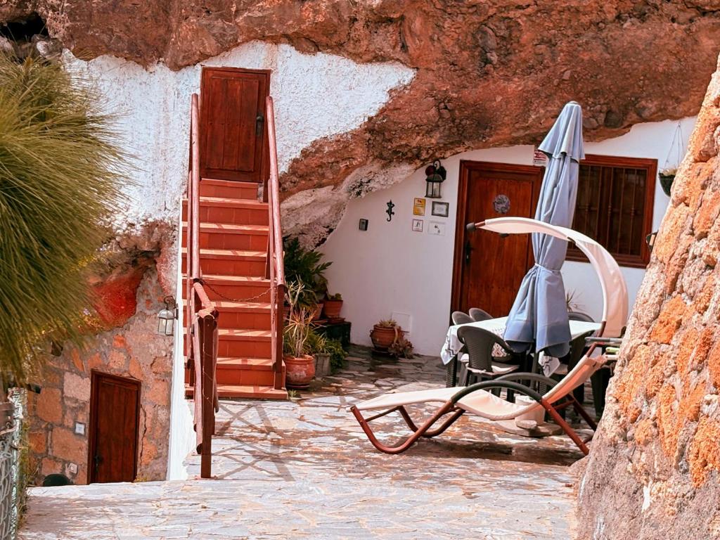 a patio with a chair and an umbrella at Finca Las Polinarias Casa Cueva en Fasnia in Santa Cruz de Tenerife