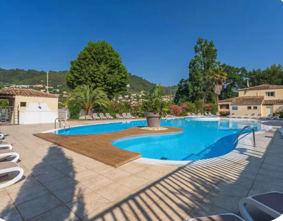 a swimming pool in a resort with chairs and trees at Chalet a louer avec piscine in Solliès-Toucas