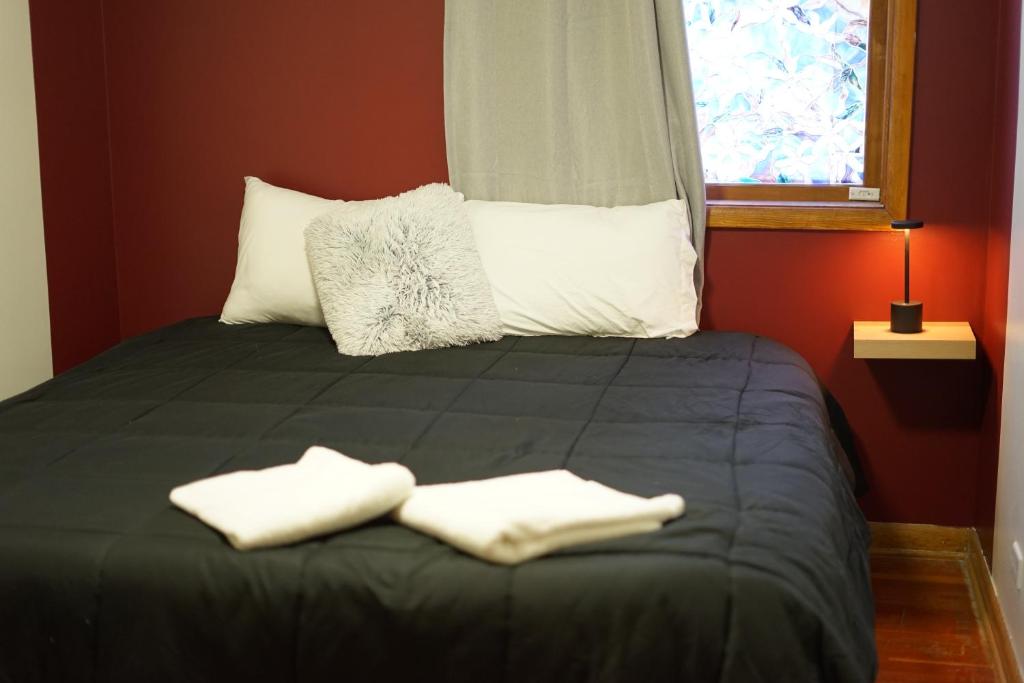 a bed with two towels on it with a window at Shiraz Suite in Calgary
