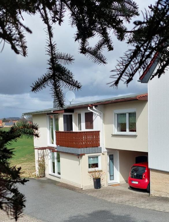 a house with a red car parked in front of it at Ferienwohnung Heidebergblick in Lawalde