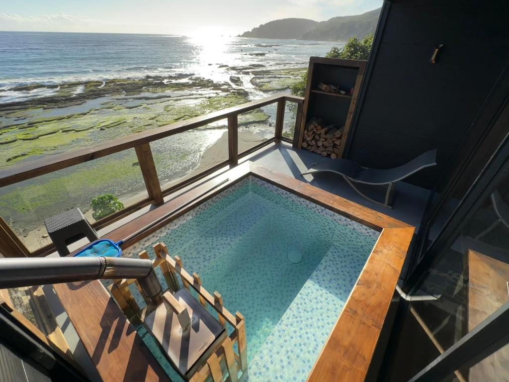 a swimming pool with a view of the ocean at Rukamar Cocholgue in Tomé