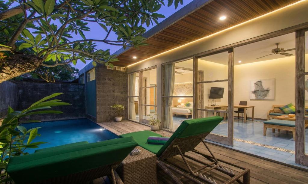 a villa with a swimming pool and a living room at Sari Dana Villas in Sanur