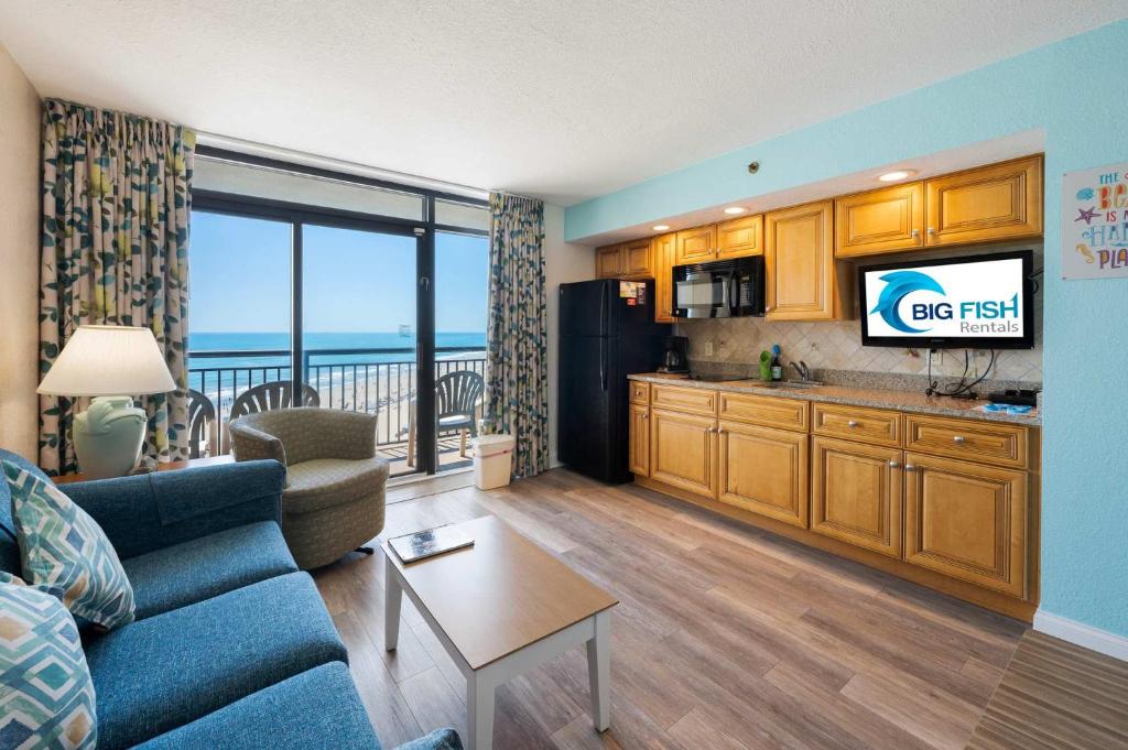 a living room with a couch and a kitchen with a view at Amazing Oceanfront Accessible Beach Amazing View in Myrtle Beach