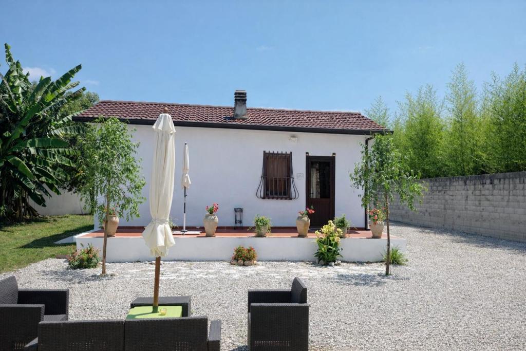 a small white house with an umbrella in front of it at Villa Mesiano in Polistena