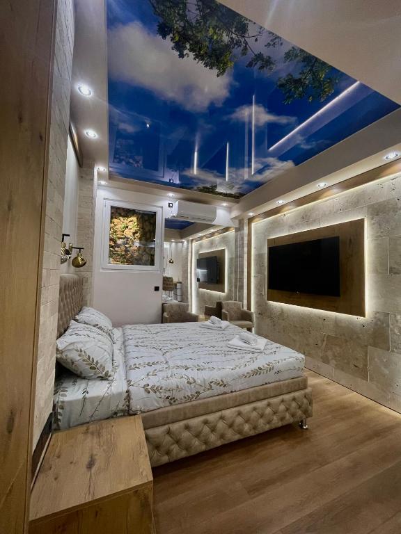 a bedroom with a large bed with a painting on the ceiling at Studio-Apartman Bingo in Pančevo