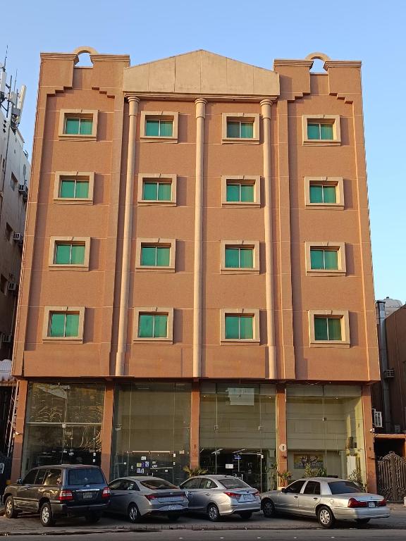 a building with cars parked in front of it at منازل لينة شقق فندقية -Manazil Lina-Private apartment in Al Hofuf