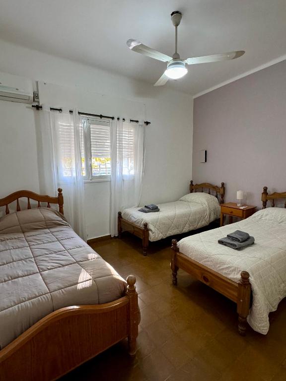 a bedroom with two beds and a ceiling fan at Departamento Lavanda in San Juan
