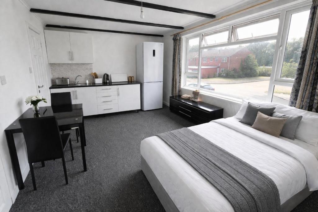 a bedroom with a bed and a desk and a kitchen at Self-contained Studio Slough, Berkshire in Canvey