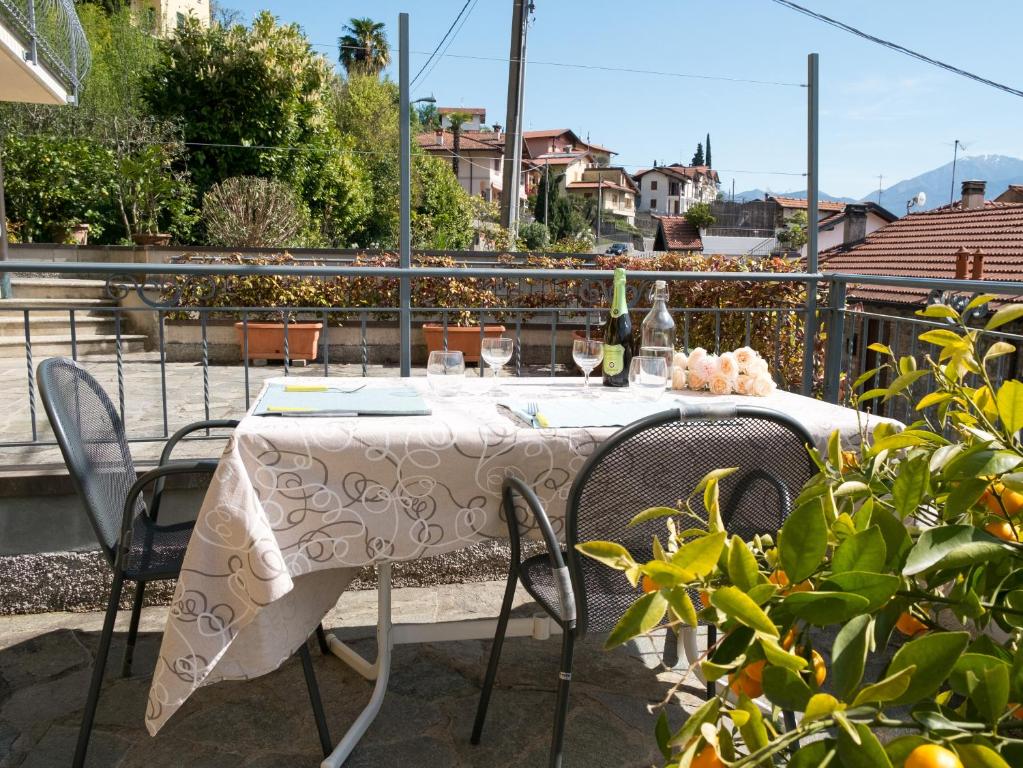 a table with chairs and wine bottles on a balcony at Il nido di Lera in Lenno