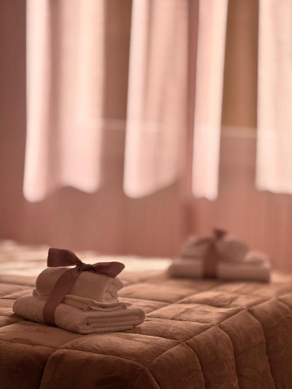 two towels on a bed with a bow on them at Hotel Gentile in Noli