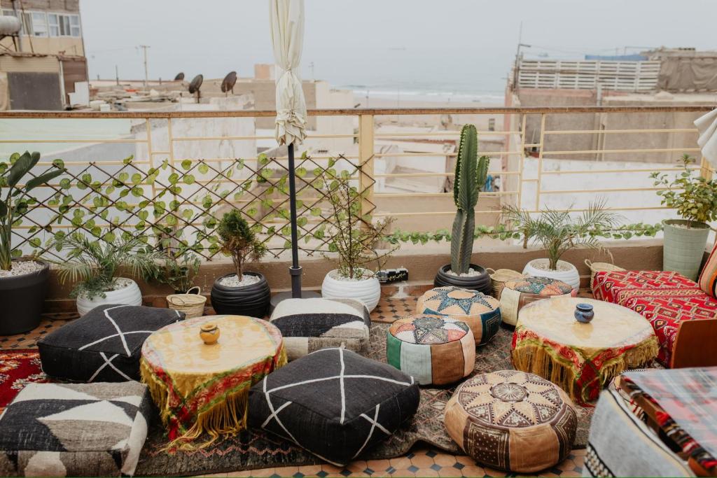 un gruppo di tavoli e sgabelli su un tetto di Anza Surf Experience Hostel ad Agadir