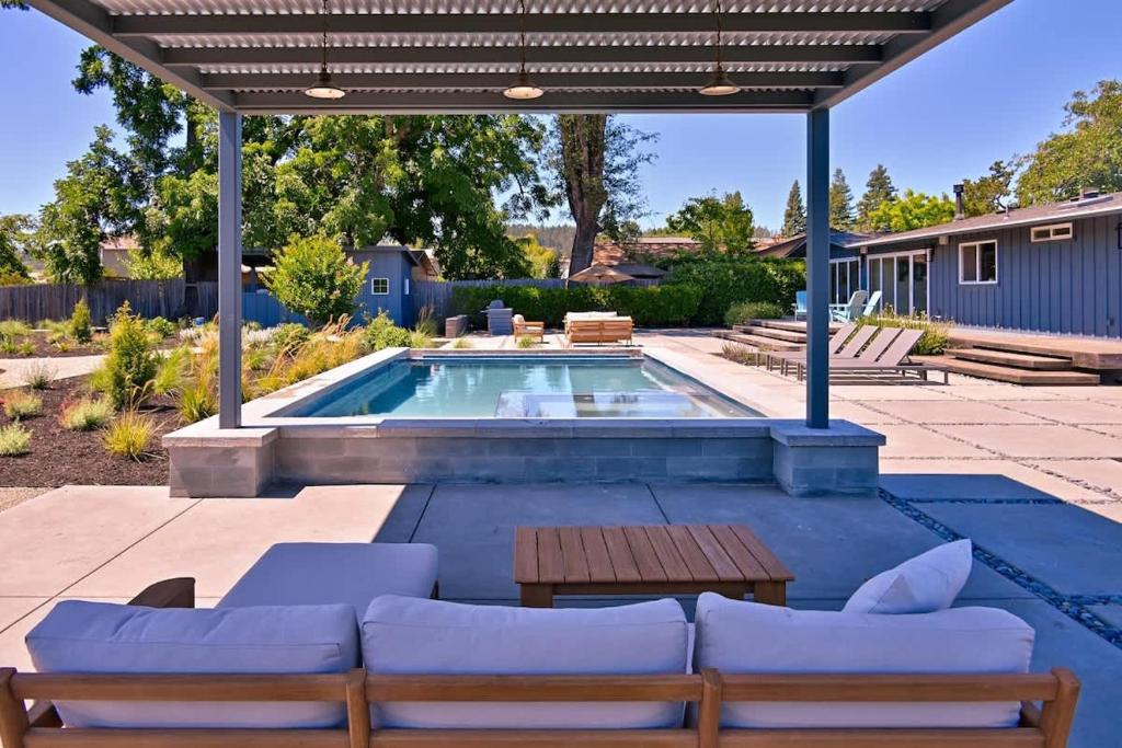 a patio with a swimming pool with chairs and a table at Haven With Pool, Hot Tub And Tastings Included in Healdsburg