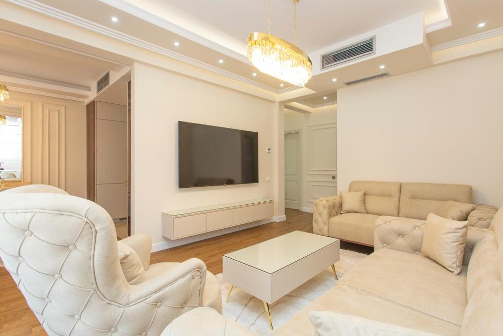 a living room with white furniture and a flat screen tv at Apartment Harmonia in Dobrota