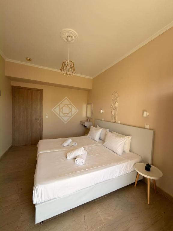 a bedroom with a large white bed with towels on it at Elenas Garden in Kavos