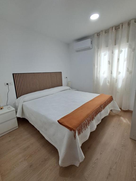a bedroom with a large bed with a wooden floor at Andrea's house in Charco del Pino