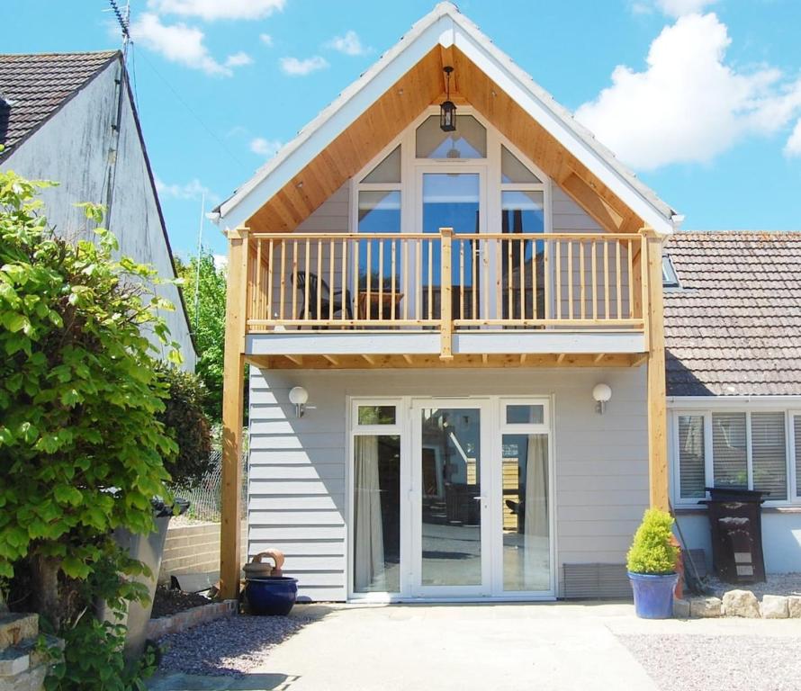 a house with a balcony on top of it at Gig Lodge Perfect Swanage Base in Swanage