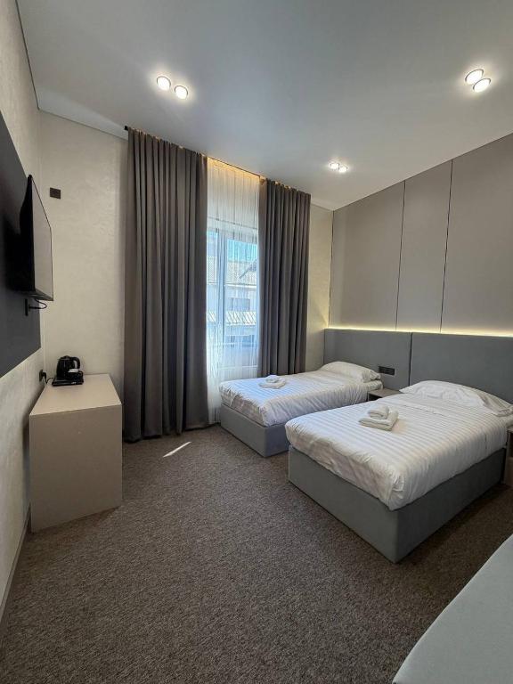 a hotel room with two beds and a television at Ave Garden in Osh