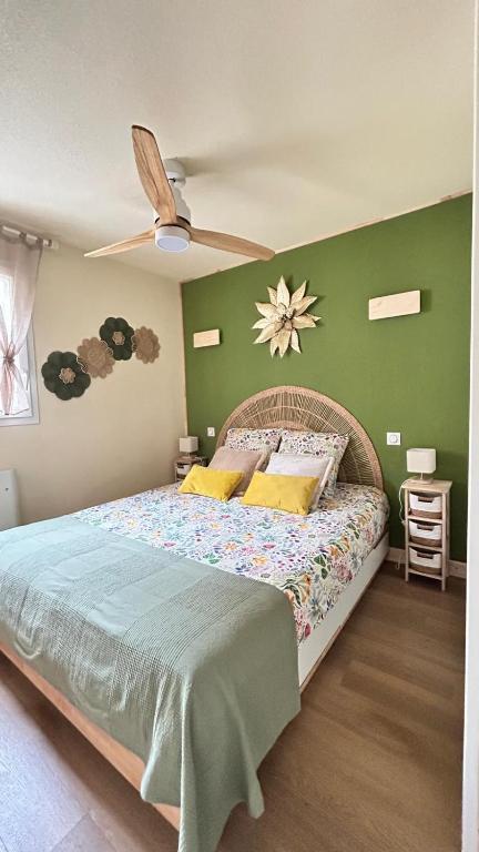 a bedroom with a bed with a green wall at Le Trésor du Lac - Casteljaloux - Lac de Clarens - Appartement - Piscine - Parking - WIFI - Accès privée Plage - Golf - Casino - Terra Aventura - So Vélo in Casteljaloux
