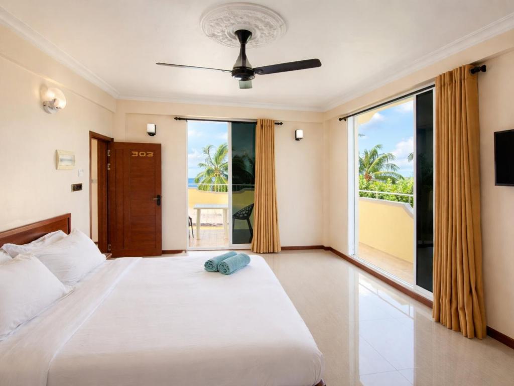 a bedroom with a bed with a view of the ocean at Noah Private Beach House in Himmafushi
