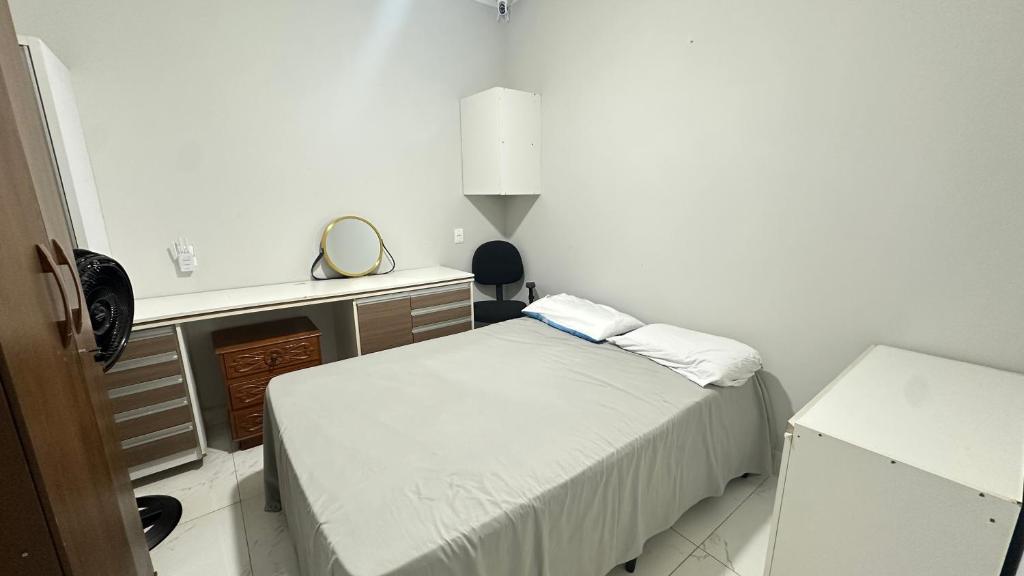 a small bedroom with a bed and a desk at Quarto com banheiro in Sao Jose do Rio Preto