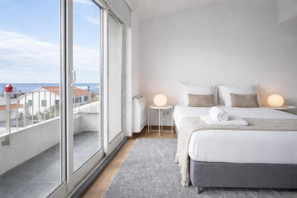 a bedroom with a bed and a large window at ins Ígnea in Madalena