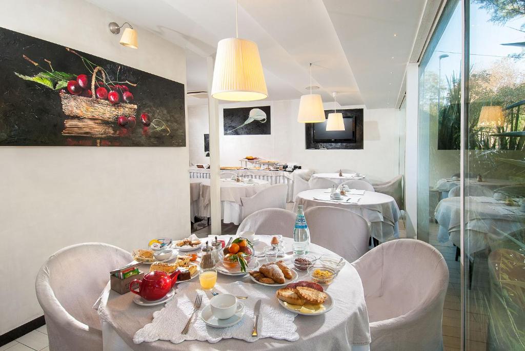 una sala da pranzo con tavolo e cibo di Hotel Mediterraneo a Pesaro