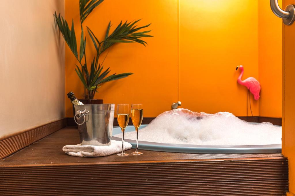 a bath tub with two champagne glasses on a table at RotoVegas Motel of Rotorua in Rotorua