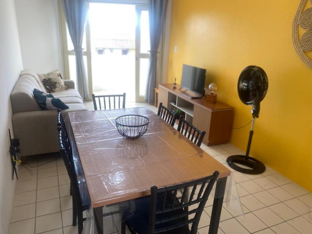 a living room with a table and a couch at Family Beach flat - frente ao mar in Barra de São Miguel