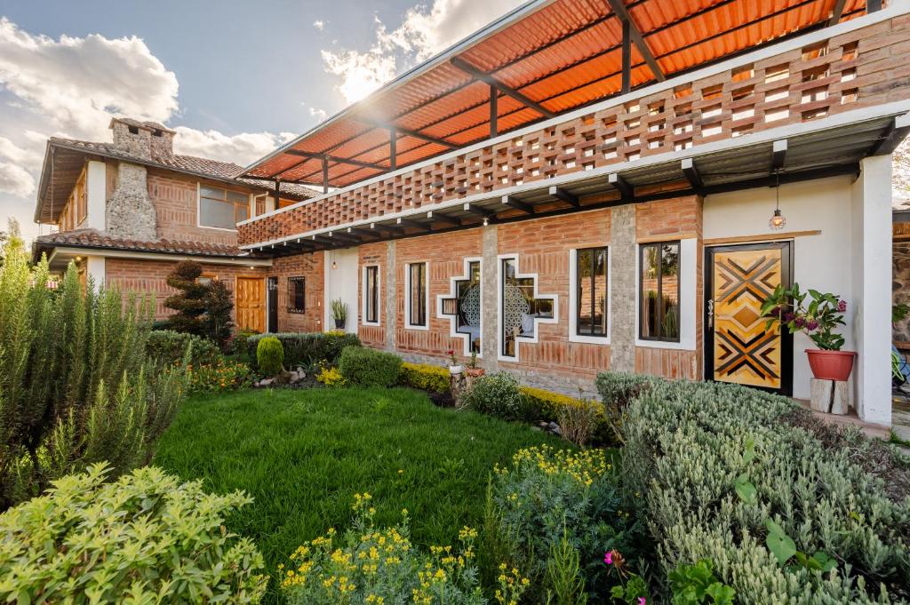 a house with a garden in front of it at Watzara Wasi Studios en Cotacachi in Cotacachi