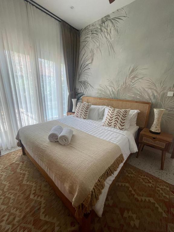 a bedroom with a large bed with towels on it at Villa Alam in Nusa Lembongan