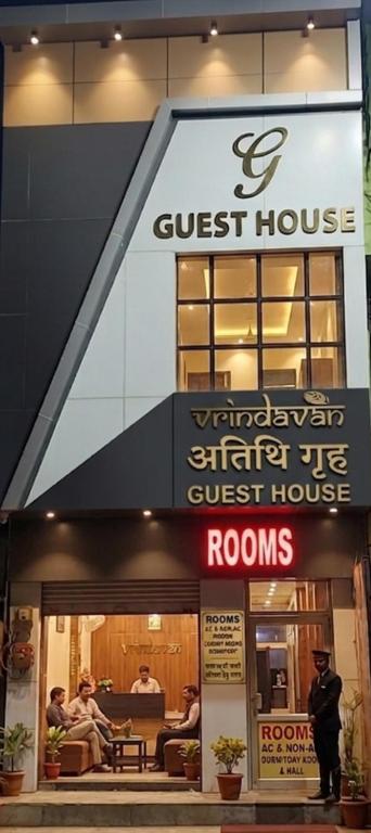 a guest house with people sitting outside of it at Hotel Vrindavan Near Prem Mandir Distance 15 min in Mathura