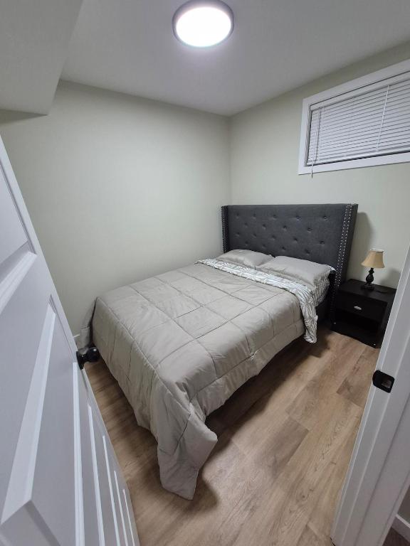 a bedroom with a bed in a white room at Clear Edge Suites in Saskatoon