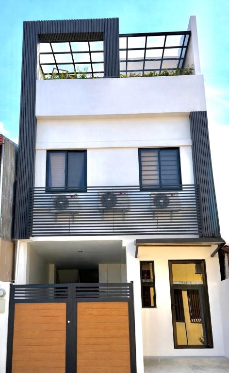 a white house with a brown door at Dasma stay - Private Jacuzzi and Skyline Views in Dasmariñas