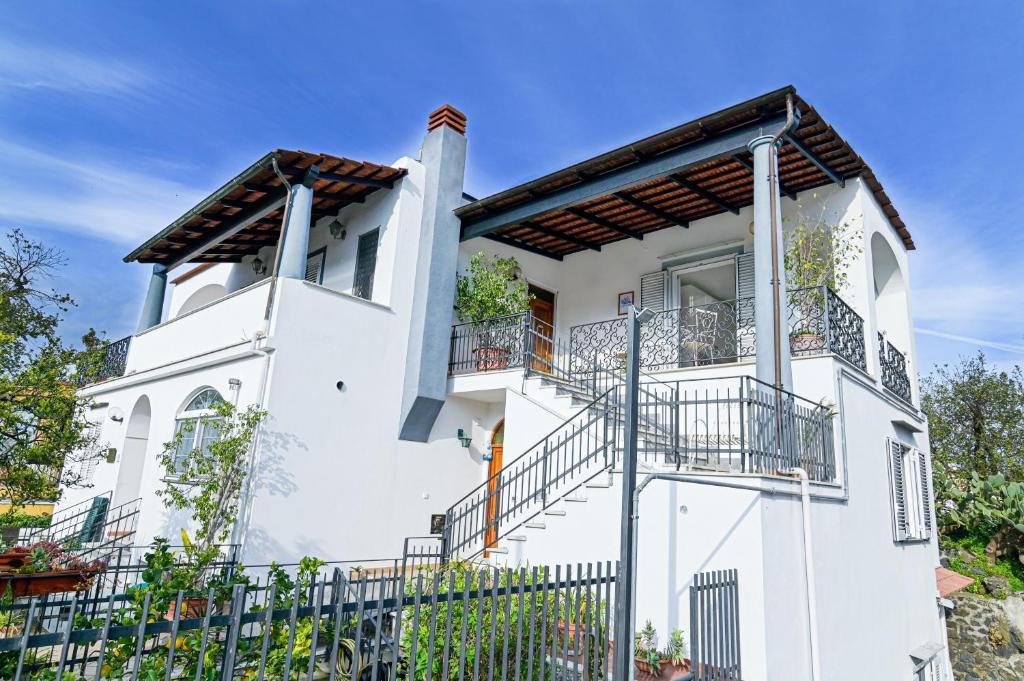 a white house with balconies and a fence at Rosa di Ischia - Holiday in Ischia Town