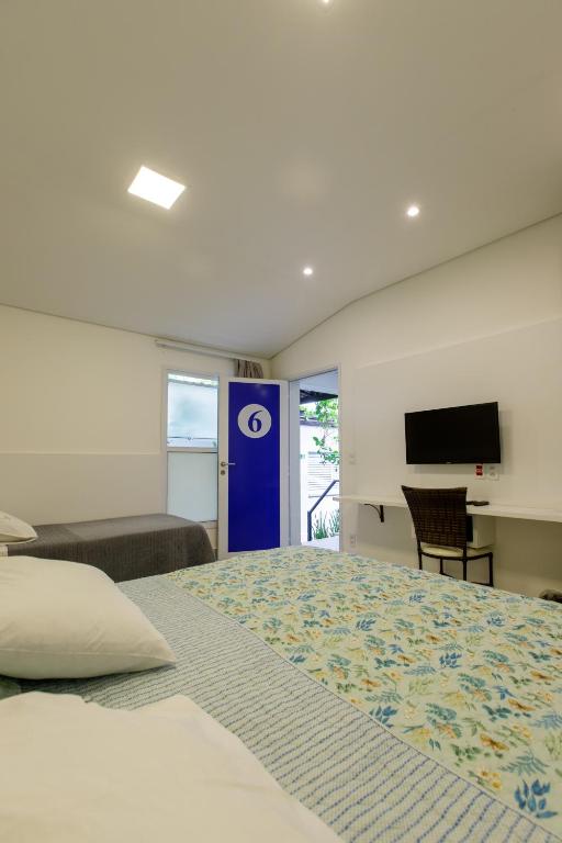 a bedroom with a large bed and a blue door at K2 RESIDENCE Campinas in Campinas