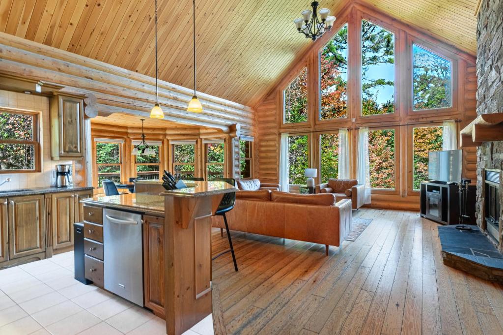 a kitchen and living room in a log cabin at Fiddler Lake Resort - Rabbit 66 in Mille-Isles