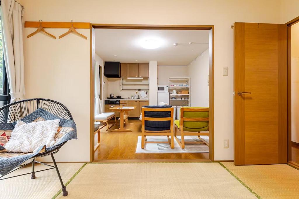a living room with a door open to a kitchen at B桜坂Sakurazaka APT in Susakiuramachi