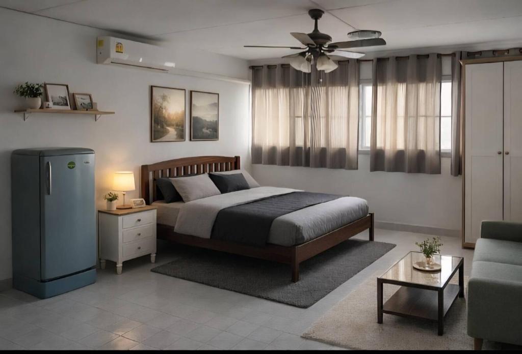 a bedroom with a bed and a couch at Ally home 0624 in Thung Si Kan