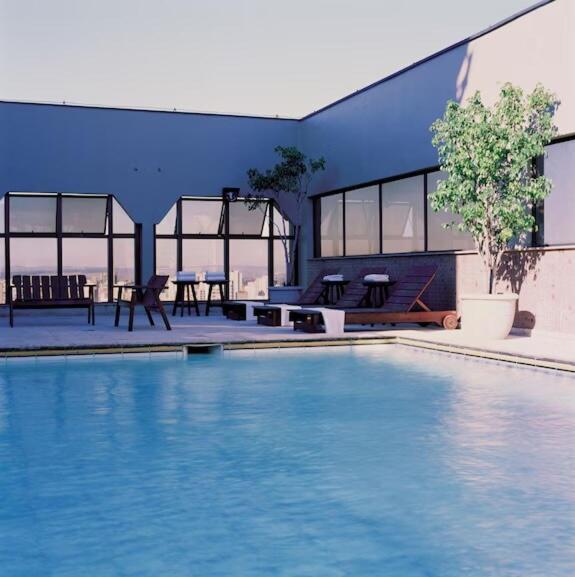 a large swimming pool with a table and chairs next to a building at Executive Flat in Apart Hotel in Campinas