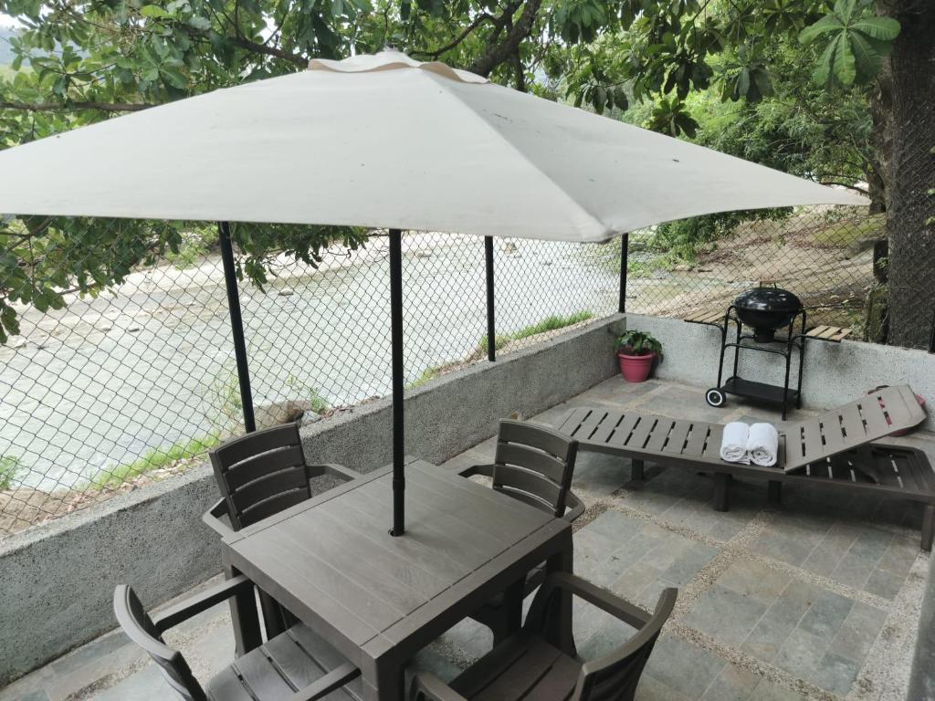 a table and chairs with an umbrella and a grill at Casa Terraza in El Zaino