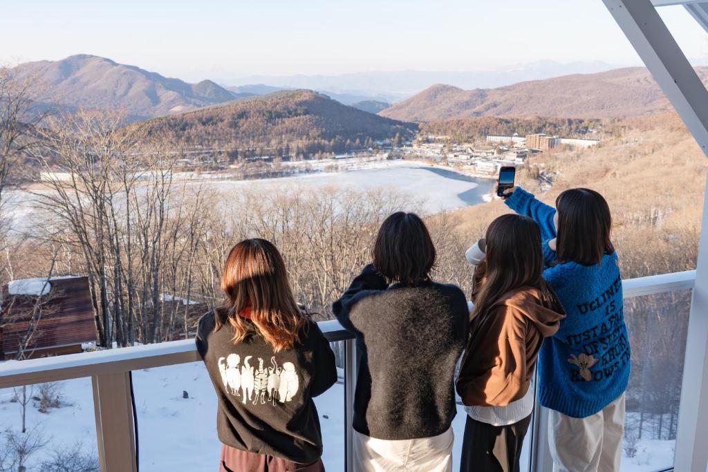 a group of girls standing on a balcony taking a picture at 白樺湖Lake View in Chino